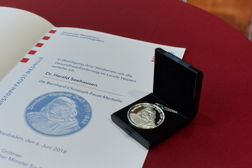 Eine Urkunde und eine Medaille liegen auf einem Tisch