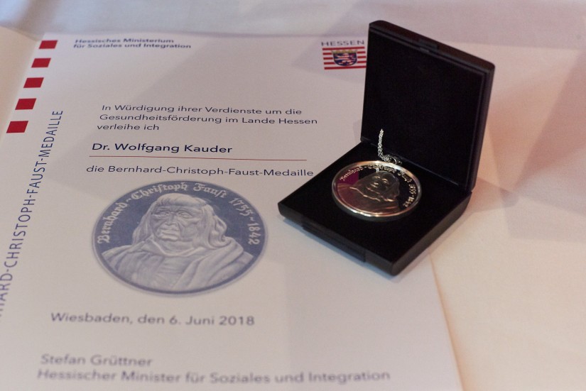 Eine Urkunde und eine Medaille liegen auf einem Tisch