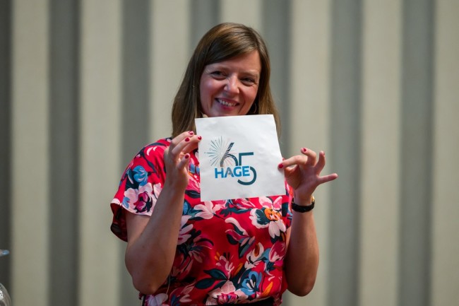 Moderatorin Stefanie Bathen mit HAGE Jubiläums-Logo