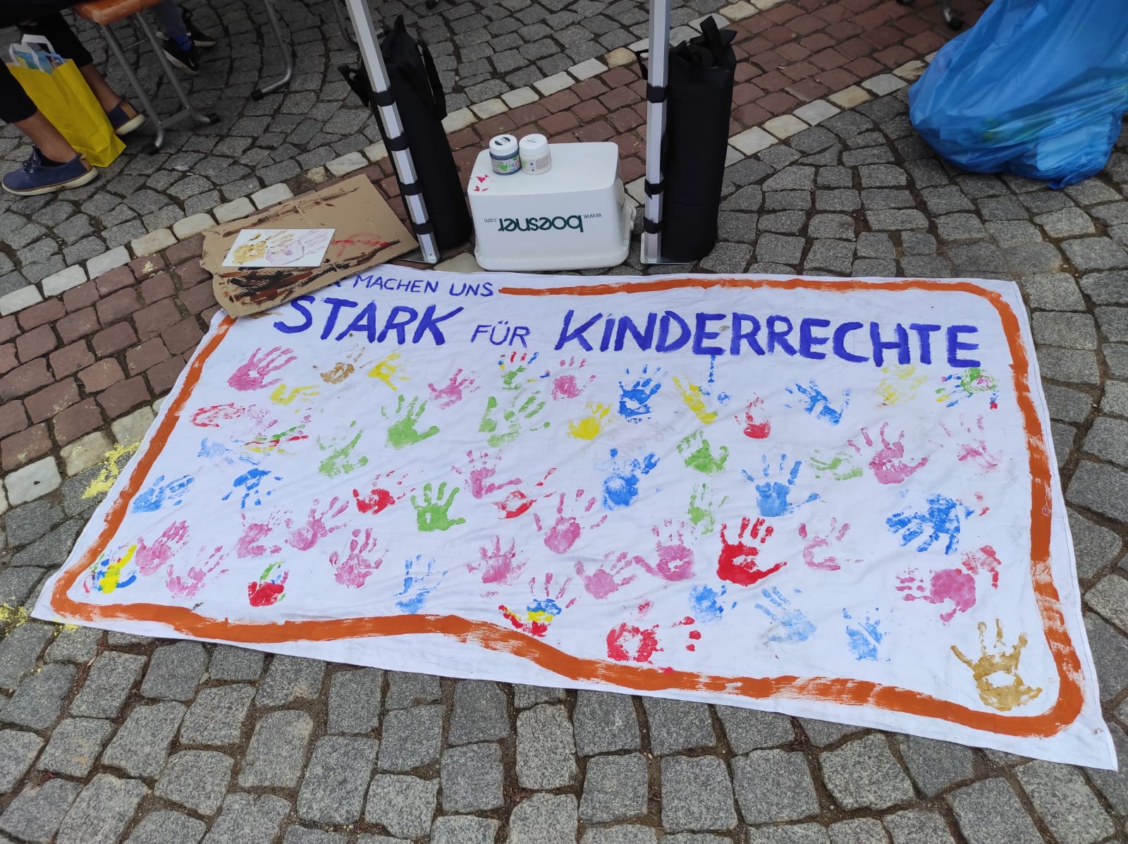Ein Banner mit dem Text "Stark für Kinderrechte" liegt auf dem Boden
