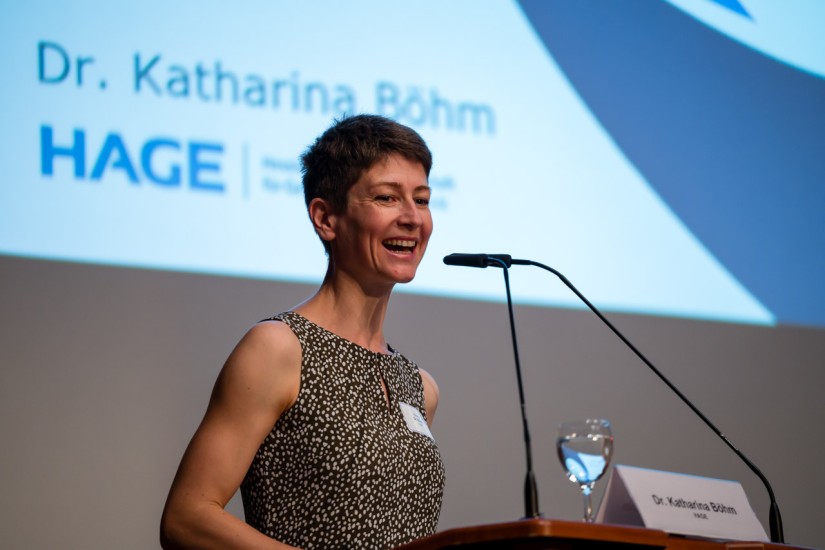 Dr. Katharina Böhm steht hinter dem Rednerput und hält einen Vortraggährend der Veranstaltung