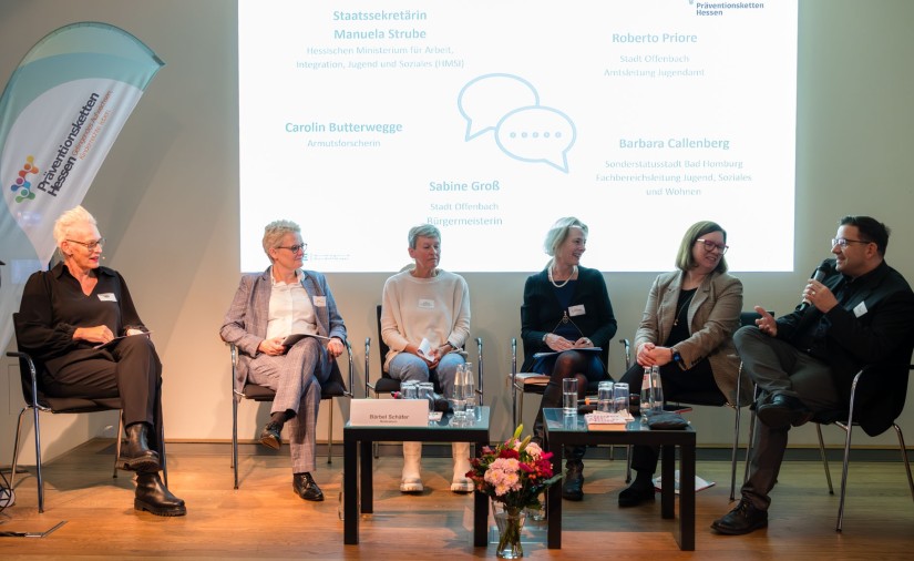 Sechs Personen sitzen auf einem Podium und diskutieren