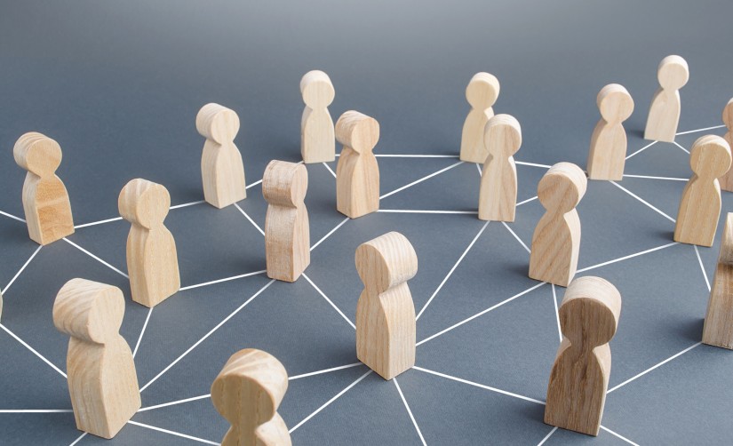 Holzfiguren stehen auf den Knotenpunkten eines Liniennetzes