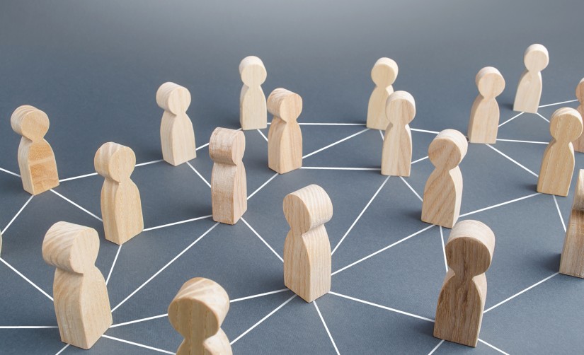 Holzfiguren stehen auf den Knotenpunkten eines Liniennetzes